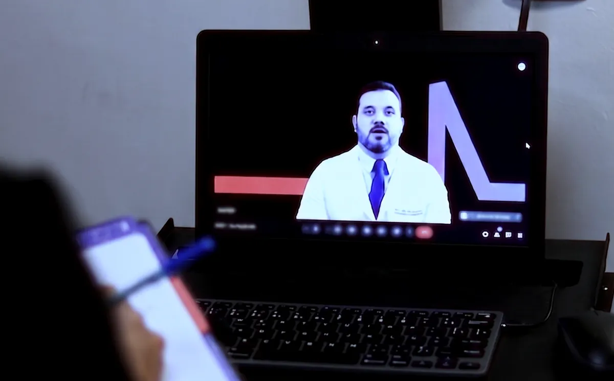 Médico plantonista anota orientações enquanto cardiologista orienta por videochamada na estação ECGPRO